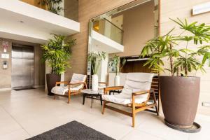a lobby with chairs and a table and plants at Lindo y Espacioso Departamento muy cerca a Miraflores in Lima