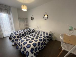 a bedroom with two beds with blue and white sheets at Coello 31 in Jaén