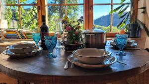 a wooden table with bowls and plates and glasses on it at Gemütliche Waldrandlage in Badenweiler Sehringen Ferienwohnung in Badenweiler