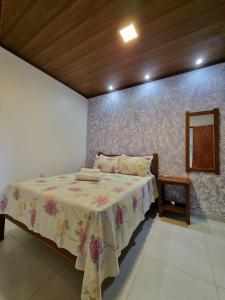 a bedroom with a bed with a table and a wall at Village São Jorge - Guest Apartment in Sao Jorge