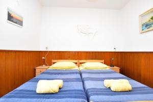 a bedroom with two beds with yellow and blue sheets at Apartments Ziva in Primošten