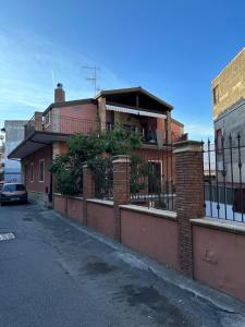 a brick house with a fence on a street at Bea’s House in Catania