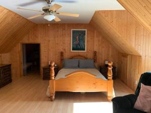 ChertseyにあるPrivate Beach, Jacuzzi & Skiのベッドルーム1室(ベッド1台、シーリングファン付)
