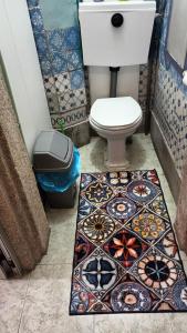 a bathroom with a toilet and a tile floor at AL-Pinheiro 62 in Porto