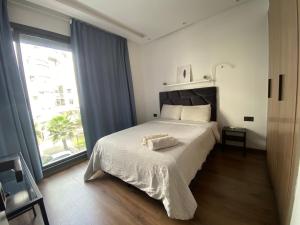 1 dormitorio con cama y ventana grande en Lovely 1-bedroom rental unit near 2mars/Habous en Casablanca