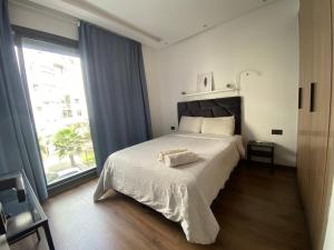 a bedroom with a bed and a large window at Lovely 1-bedroom rental unit near 2mars/Habous in Casablanca