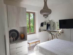 MASSARO APARTMENTS VIA CAVORSO CHIETI Abruzzo في كييتي: غرفة نوم بيضاء مع سرير ومرآة