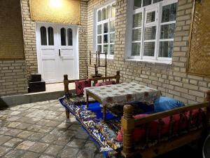 una panchina con un tavolo di fronte a una casa di Barlos - уютная, семейная атмосфера a Bukhara