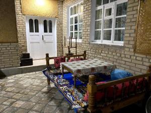 a bench with a table in front of a house at Barlos - уютная, семейная атмосфера in Bukhara