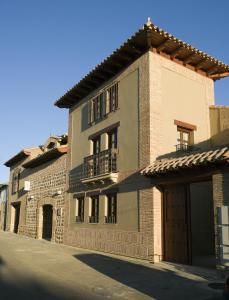 a large brick building with balconies on a street at Posada Los Condestables Hotel & Spa in Villalpando