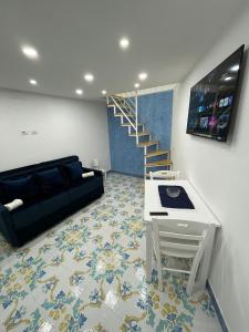 uma sala de estar com um sofá, uma mesa e uma escada em Domus Myosotis Apartment Napoli em Nápoles