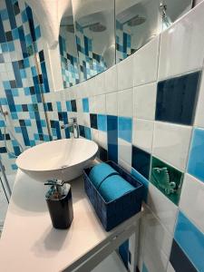 een badkamer met een witte wastafel en blauwe tegels bij Domus Myosotis Apartment Napoli in Napels