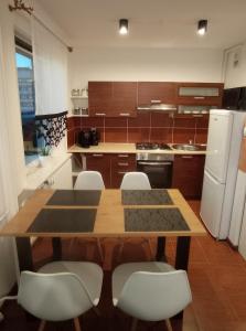 cocina con mesa de madera y electrodomésticos blancos en MK Apartament III, en Rzeszów