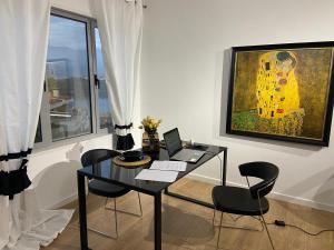 a room with a desk with a laptop and a painting at MB luxury apartments in Tirana