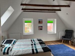 a bedroom with a bed and two windows at Bakker Huus DG in Emden
