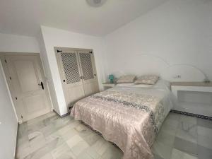 トレビエハにあるPerla del Marの白いベッドルーム(ベッド1台、ドア付)