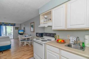 a kitchen with a sink and a stove top oven at Ocean View Double Queen Suite with Full Kitchen! Sea Mist Resort 50804 - Perfect for 2-4 guests! in Myrtle Beach