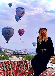 a woman standing on a blanket with hot air balloons at Sevin Stone Hotel in Goreme