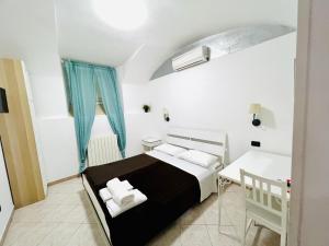 a small bedroom with a bed and a table at Hotel Pisa in Rome