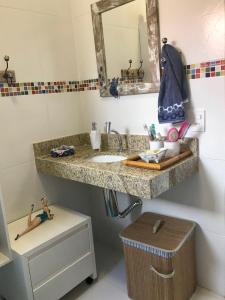 La salle de bains est pourvue d'un lavabo et d'un miroir. dans l'établissement Casa Azul, Long Beach Unamar Cabo Frio, à Tamoios