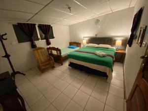 a bedroom with a bed and a table and chairs at Nanda Parbat Hostal in San Rafael Cedros