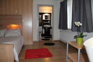 a small bedroom with a bed and a bathroom at Hotel De Ploeg in Diepenbeek