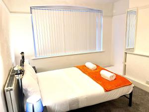 a bedroom with a bed with two towels on it at Lotus Home Wallasey in Wallasey