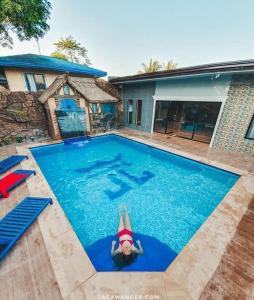 une femme se pose dans une piscine dans l'établissement The Shire Private Resort, à Bago