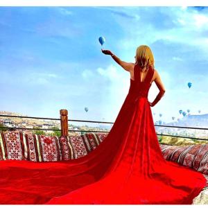 a woman in a red dress holding a balloon at Sevin Stone Hotel in Goreme