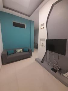a living room with a couch and a flat screen tv at Apartamentos Morabeza in Mindelo