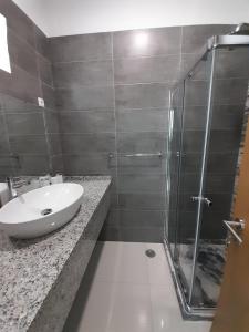 a bathroom with a sink and a glass shower at Apartamentos Morabeza in Mindelo