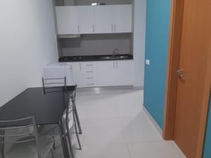 a kitchen with a table and chairs and a sink at Apartamentos Morabeza in Mindelo