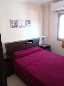 ein Schlafzimmer mit einem großen Bett mit einer roten Tagesdecke in der Unterkunft Departamento en Carlos Paz para familias in Villa Carlos Paz