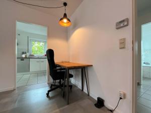 a dining room with a table and a chair at favstay Industrialstyle 2-Zimmer 60qm mit Balkon, Panarbora Fernblick, 55" TV & Netflix, 55Mbit WLAN, Parkplatz in Waldbröl