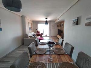 comedor con mesa y sillas y sala de estar en Apartamento de lujo en primera línea de playa, en Torremolinos