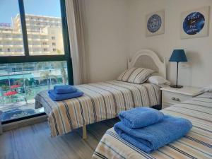 2 camas en una habitación con ventana en Apartamento de lujo en primera línea de playa, en Torremolinos