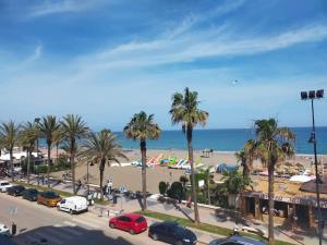 un aparcamiento con palmeras y la playa en Apartamento de lujo en primera línea de playa, en Torremolinos