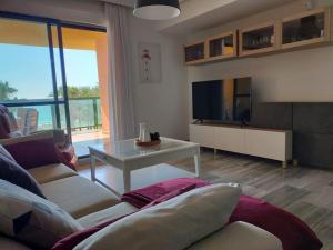 sala de estar con sofá y mesa en Apartamento de lujo en primera línea de playa, en Torremolinos