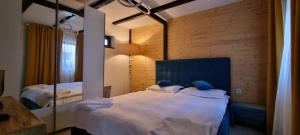 ein Schlafzimmer mit zwei Betten und einem Spiegel in der Unterkunft Tiny Dream House in Buşteni