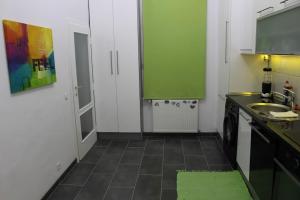 una pequeña cocina con armarios verdes y fregadero en my happy place, en Viena