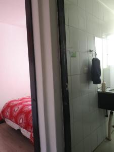a bathroom with a shower and a red bed at Hostal Vitalia in Santiago