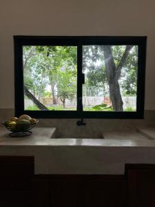 a kitchen sink with a window and a bowl of fruit at Casa Árabe in Cenote Azul