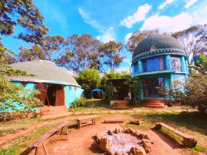 um edifício azul com uma cúpula e uma fogueira em Espaço Cultural Lotus - Suítes, Hostel e Camping em Alto Paraíso de Goiás