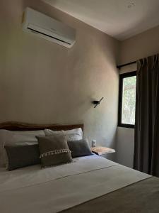 a bedroom with a large white bed with a window at Casa Árabe in Cenote Azul