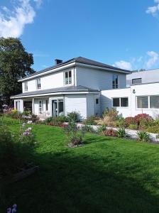 a white house with a lawn in front of it at Le Clos Louisiane in Saint-Loup-Hors