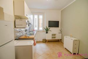 a kitchen with a white refrigerator and a sink at Borgo Cocconi 33 in Parma