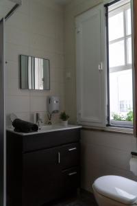 uma casa de banho com um lavatório, um WC e um espelho. em CASA DA AVÓ ZIRINHA em Viseu