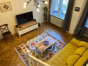 a living room with a yellow couch and a television at The Old Stairs in Sofia