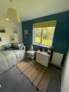 Schlafzimmer mit einem Bett und einem Fenster in der Unterkunft Secluded 3 bed cottage in private parkland in Brockenhurst