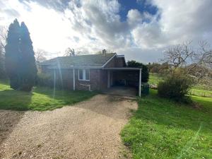 a brick house with a garage in the yard at Secluded 3 bed cottage in private parkland in Brockenhurst
